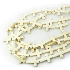 Howlit syntetyczny kremowy krzyż ok. 25x18mm