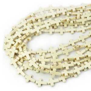 Howlit syntetyczny kremowy krzyż ok. 16x12mm
