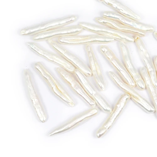 Naturalna perła w kształcie patyczka o wymiarach około 3-6x25-35 mm, o delikatnym, perłowym połysku