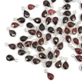 Zawieszki z naturalnym granatem w formie kropli fasetowanej ok.11x6 mm, oprawione w srebro 925, idealne do naszyjników i bransoletek, ujęcie z góry, leżące luzem na białym tle