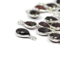 Zawieszki z naturalnym granatem w formie kropli fasetowanej ok.11x6 mm, oprawione w srebro 925, idealne do naszyjników i bransoletek, widok z perspektywy bocznej, leżące luzem na białym tle