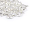 Przezroczysty kryształ górski w kształcie kropli o wymiarach ok. 11x6 mm, fasetowany, w oprawie ze srebra 925, zawieszka do biżuterii. Zbliżenie na kamienie
