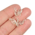 Przezroczysty kryształ górski w kształcie kropli o wymiarach ok. 11x6 mm, fasetowany, w oprawie ze srebra 925, zawieszka do biżuterii. Zdjęcie na dłoni w celu lepszego ukazania koloru i rozmiaru.