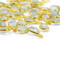 Błękitny akwamaryn w kształcie kropli o wymiarach ok. 11x6 mm, fasetowany, w oprawie ze srebra pozłacanego 925, zawieszka do biżuterii. Zbliżenie na kamienie