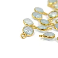 Okrągłe, fasetowane zawieszki z akwamarynu błękitnego, ok.10x7 mm, oprawione w srebro pozłacane 925, idealne do naszyjników i bransoletek, widok z perspektywy bocznej, leżące luzem na białym tle.