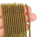 Kamienie w formie drobnych oponek hematytu w kolorze złotym, w rozmiarze ok. 3x1mm. Zdjęcie na dłoni w celu lepszego ukazania koloru i rozmiaru
